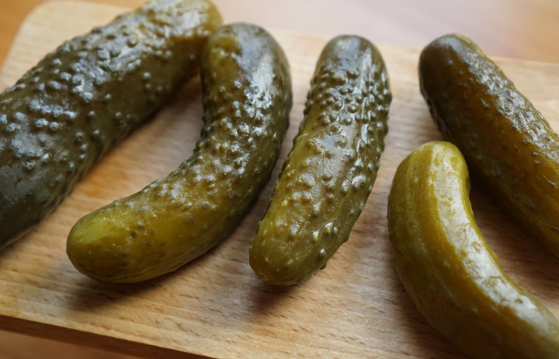 pickled cucumbers on a wooden surface skyradar